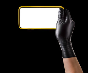 Hand in black glove holding mobile phone with blank screen isolated on black