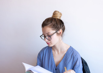 European girl reading her book. Home Office.