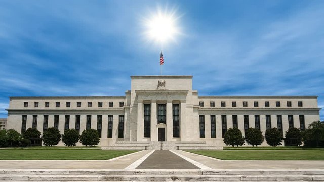 A beautiful blue sky time lapse with the sun shining brightly over the Federal Reserve Building in Washington D.C.