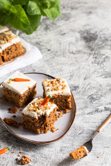 pieces of carrot cake with walnuts with icing cream on a light background. tinting. selective focus