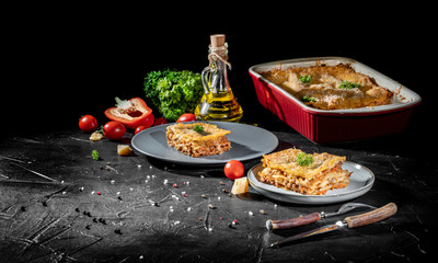 Traditional italian lasagna with vegetables, minced meat and cheese On a dark background. Homemade meat lasagna