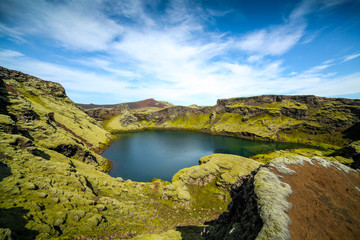 Volcanic lake inside of a crater in Iceland. Volcanic crater lake in southern Iceland. Highland of Iceland. Beautiful crater lake with a turquoise water color covered with green moss