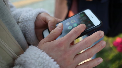 Seoul, Korea - Hand holding a smart phone. Close up image of touching smart phone outside.