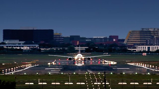 Airplane during take off from Hamburg airport (HAM). Late evening with runway ilumination. Visible heat haze, cause of high temperature on the runway
