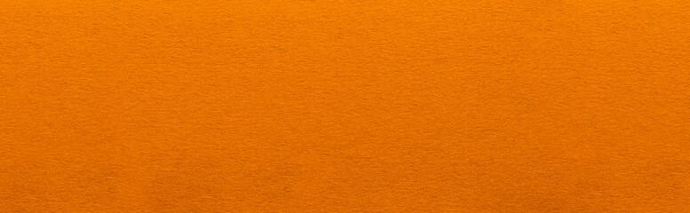 Good quality porous orange color cardboard paper texture close-up.