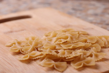 Italian Farfalle Pasta on the light beige rustic background