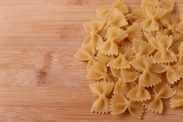 Italian Farfalle Pasta on the light beige rustic background