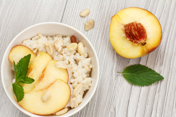 Sorghum salad with nuts and fresh peach on gray boards.
