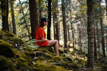 Sad young european girl sitting in a forest