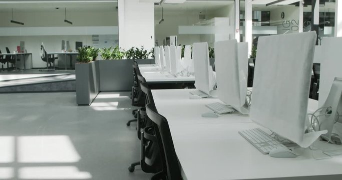 Empty rental office with computers wrapped in cover