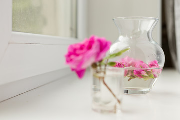In the foreground in a small glass stands a pink tire flower