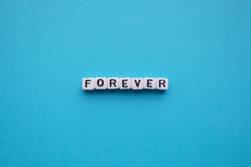 Forever word cubes on a blue background