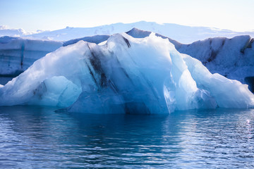 Icebergs floating. Ices and volcanic ash. Glacier lagoon. Melting ice. South coast Iceland.Volcanic ash on the arctic ice. Ice age glacier crevasse melting fast. Global warming. The edge of a glacier