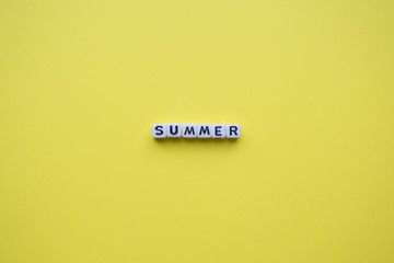 Summer word cubes, on a yellow background.