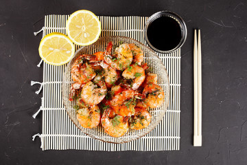 fried king prawns in a plate on a bamboo mat, lemon, dill