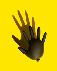 Obraz premium Disposable black latex glove to protect your hands from coronavirus, inflated like a balloon. The concept of protecting hands from coronovirus infection. 