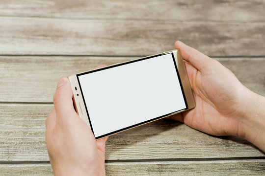Man's hands using and showing the phablet horizontally.