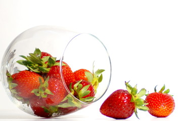 large strawberries in an inverted glass on a light background with bright lighting close-up