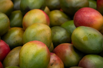 Page full of green yellow and red Mangos at a market
