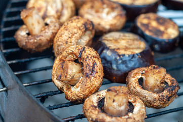 Grilled mushrooms on the background of grilled eggplant. Selective focus.