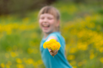 smiling girl with dandelion bouquet, summer background