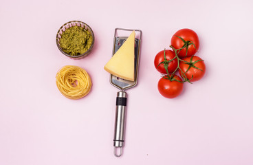 Italian Food Background Dry Pasta Tagliatelle Raw Tomatoes Bowl of Pesto Parmesan Cheese Top View Pink Background Italian Food