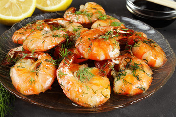fried king prawns in a plate, lemon, dill, close-up