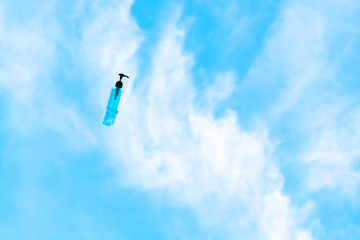 Naklejka na ściany i meble Antiseptic alcohol bottle floating on blue sky background, Campaign to prevent the spread of the Corona virus (Covid-19). New normal concept.