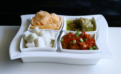 The menu for Eid Mubarak in Indonesia. Rice cake, Indonesian chicken curry or opor ayam, sambal goreng krecek and crackers.