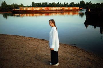 Naklejka premium Girl near the beach on the sunset
