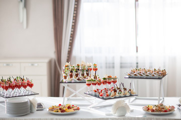 Table with sweets, buffet with cupcakes, candies. Candy bar, a table with sweets and desserts. Buffet with delicious cupcakes, cake pops, biscuits. Wedding, birthday and surprise concept.