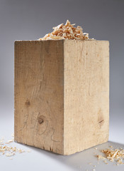 wooden cube with shavings on a gray background