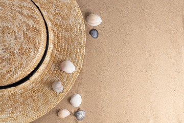 Fototapeta na wymiar Summer vacation concept. Hat and shells on sand background with a copy of space. Summer background