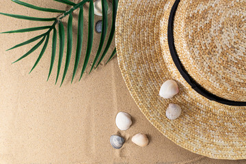 Summer vacation concept. Hat and shells on sand background with a copy of space. Summer background