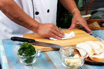 Chef cleaning wooden broad with tissue paper