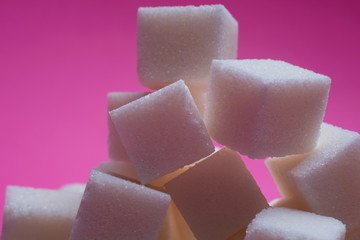 Sugar cubes on a bright pink background. Macro photo.