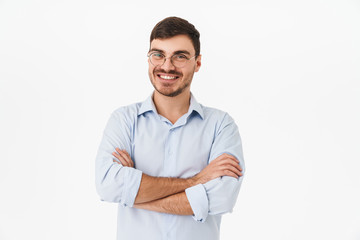 Photo of joyful young man posing with hands crossed and smiling