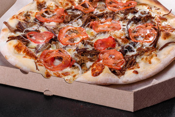 Fresh hot pizza with meat, mushrooms, cheese and tomatoes made in an oven