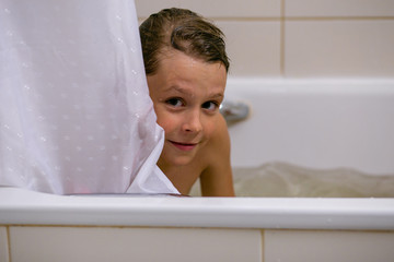 horizontal closeup portrait of a cheerful ten year old boy in the bathroom © Serafima