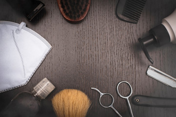 Fototapeta na wymiar Barber tools on wood dark background,scissor,razor,brush,barber machine,black comb,soap dispenser, protective face mask and sanitizer alcohol gel.