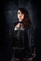 Young woman with scarified face, wearing a studded leather jacket