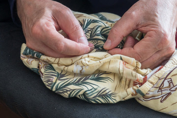 Man sewing a new button on a fashionale shirt