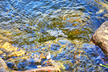 Close up of colorful waves on water as nature background.