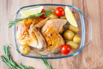 baked chicken with mushrooms and potatoes close-up in a baking dish on a table. horizontal top view from above