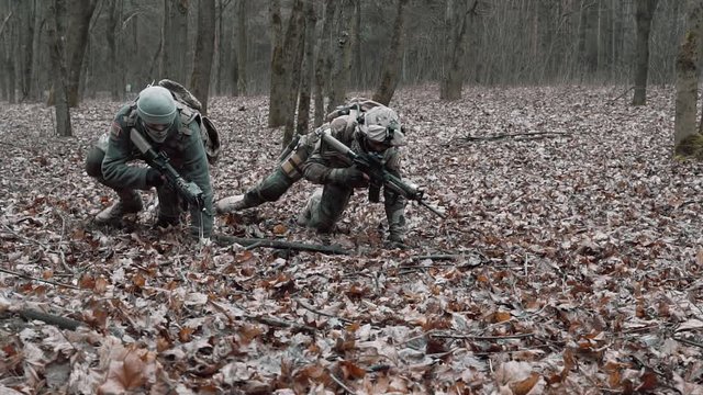 soldiers lie down on the ground getting ready to shoot in slow motion