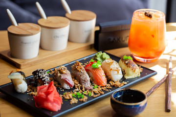 Nigiri sushi with salmon, eel, tuna and prawn, served on transparent plate. Delicious traditional Japanese food, tasty seafood, restaurant concept, food background.
