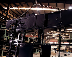 Large steel plates hang inside the heavy-duty factory