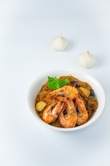 Casseroled shrimps roasted with glass noodles or prawns with Vermicelli Noodles in white blow with chinese celary on the top view. Asian Food Thai fusion style. famous food in Thailand national dish.
