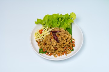 Crispy Catfish spicy Salad Served With Shredded Green Mangoes,green Cabbage, fried dried Chilies and Peanuts fried Isolated on White Background. Famous traditional food in Thailand and Asia.