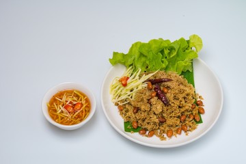 Crispy Catfish spicy Salad Served With Shredded Green Mangoes,green Cabbage, fried dried Chilies and Peanuts fried Isolated on White Background. Famous traditional food in Thailand and Asia.